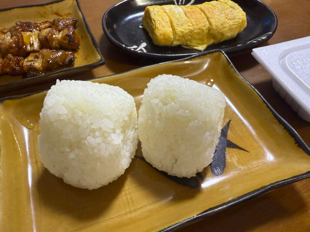 令和7年10月18日 今年の新米を試食しました 試食恒例の献立。具のないおにぎりをじっくり味わう。