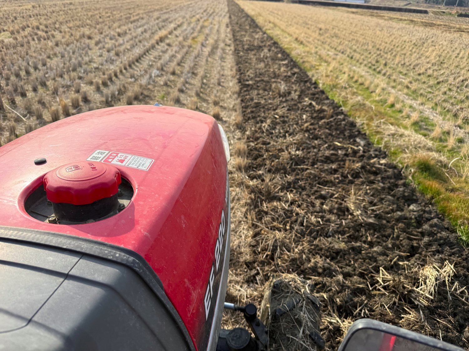 赤いヤンマートラクターで耕起